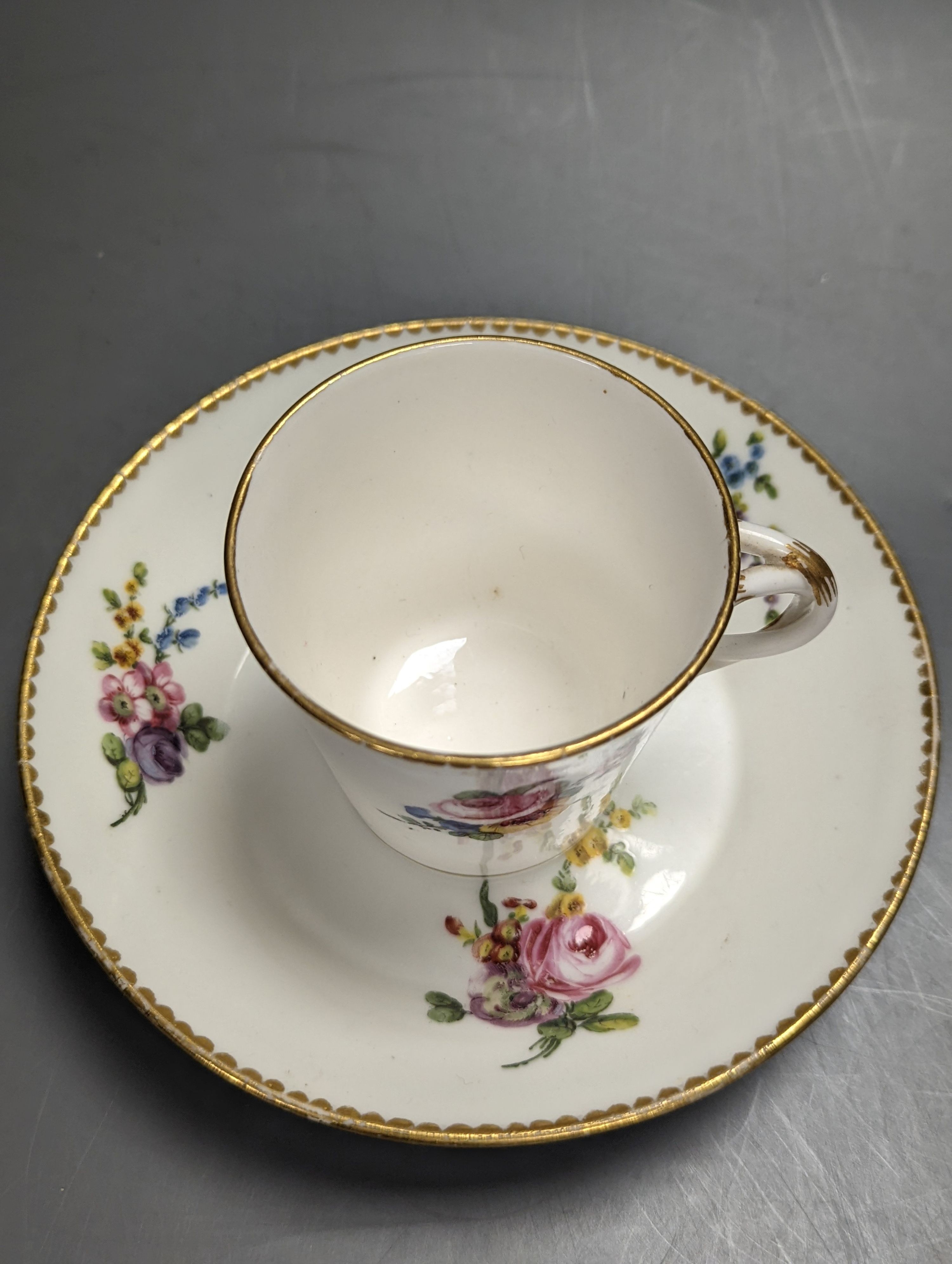 A Sevres tapering cup with entwined handle and cover and stand painted with flowers, date code for 1780, painters mark for Le Bel jnr., square incised marks, height 10.5cm